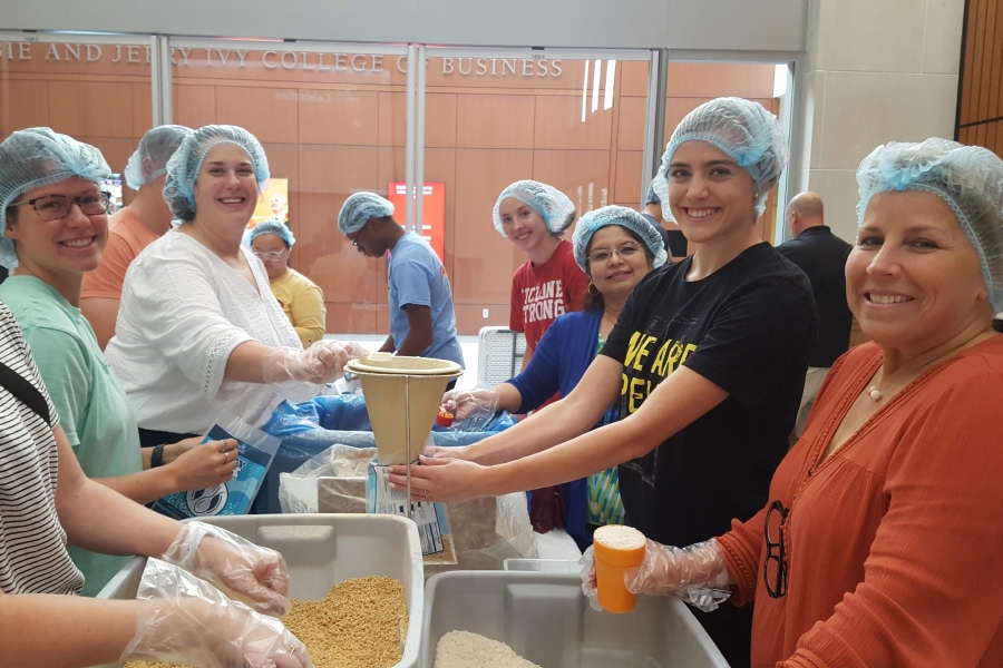 Ivy students and staff package meals at the Business Week 2022 service project.