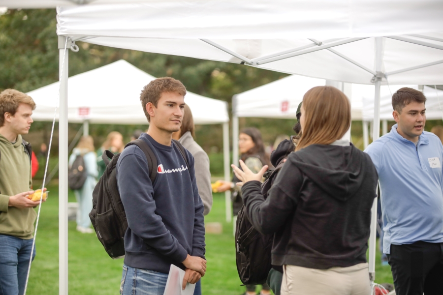 A student listens to a former intern at the 2023 InternChips and Queso event at Iowa State University.