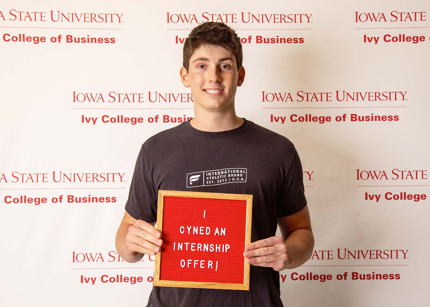 Jack Turcotte holding a sign that says he signed an internship offer.